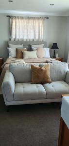 ein Sofa mit Kissen darauf im Schlafzimmer in der Unterkunft Dragonflycottagebnb in Grovetown