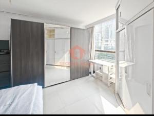 ein Schlafzimmer mit Bett, Schreibtisch und Fenster in der Unterkunft Newly Apt taman Rasuna 3BR Pool, Wi-Fi, Netflix in Jakarta