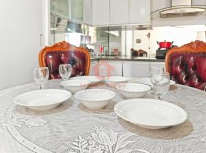 einen Tisch mit Tellern und Weingläsern auf dem Tisch in der Unterkunft Newly Apt taman Rasuna 3BR Pool, Wi-Fi, Netflix in Jakarta + 15 Fotos