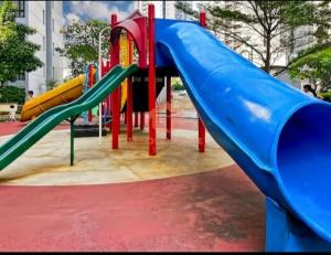 ein Spielplatz mit Rutsche in einem Park in der Unterkunft Newly Apt taman Rasuna 3BR Pool, Wi-Fi, Netflix in Jakarta