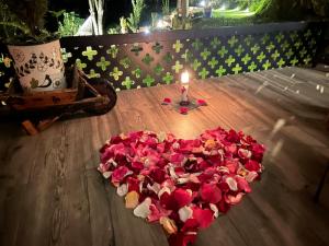een hart van rozen en een kaars op een houten vloer bij Suite de lujo con naturaleza y BBQ cerca de Cuenca in Cuenca