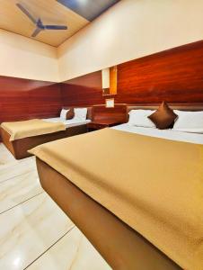 a hotel room with two beds and a ceiling at HOTEL OM PALACE NEAR MAHAKAL MANDiR in Ujjain