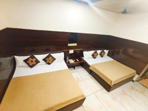 a hotel room with two beds and a television at HOTEL OM PALACE NEAR MAHAKAL MANDiR in Ujjain