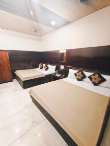 a hotel room with two beds in a room at HOTEL OM PALACE NEAR MAHAKAL MANDiR in Ujjain