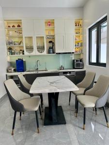 a kitchen with a table and chairs and a sink at Thu Ha Homestay - VTĐ7-61 - Vinhomes Ocean Park 3 in Ðình Loan