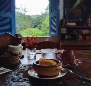 a table with a bowl of food on a table at Casa Charme Jericó Guaramiranga in Guaramiranga