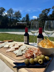 een houten tafel met wijnglazen en een bord eten bij Alma Andina in Puelo