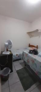 een slaapkamer met 2 aparte bedden en een ventilator bij Casa compartilhada para Natal Luz e FIG in Garanhuns