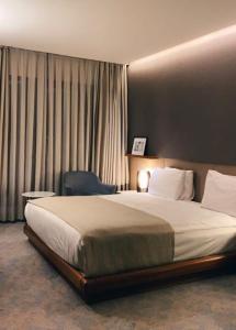 a bedroom with a large bed and a chair at hotel red creek in Visakhapatnam