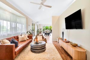a living room with a couch and a flat screen tv at The Hideaway in Tintenbar
