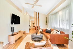 a living room with a couch and a tv at The Hideaway in Tintenbar