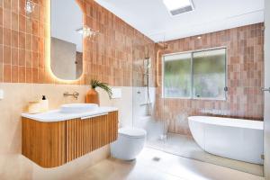 a bathroom with a tub and a toilet and a sink at The Hideaway in Tintenbar +26 photos