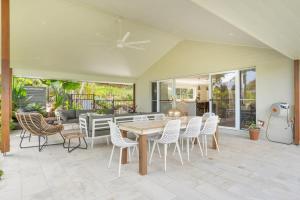 a patio with a wooden table and chairs at The Hideaway in Tintenbar
