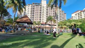 a group of people in a park with a large building at ARIAN GOLDSAND SEAVIEW APARMENT glory beach resort in Port Dickson