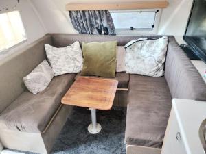 a living room with a couch with pillows and a table at Redwood Valley B and B Caravan Retreat in Redwoods Valley