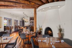 a restaurant with tables and chairs and a fireplace at Chipeta Lodge in Ridgway