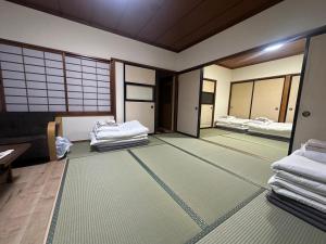 una habitación con 2 camas y un montón de toallas en Suzuya, en Hanabuchihama