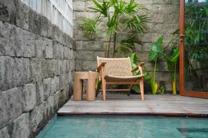 Jumah Bingin by Melali - private villas في Bingin Beach: كرسي وطاولة على سطح بجوار حمام السباحة
