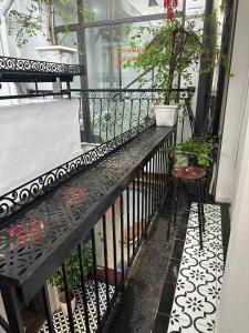 a balcony with a bench and a table and plants at Hanoi Golden Hotel in Hanoi