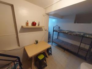 a small room with a table and a shelf at Kochimoto Guestroom in Baguio