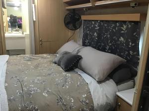 a bedroom with a bed with a black and gray blanket at Redwood Valley B and B Caravan Retreat in Redwoods Valley +7 photos
