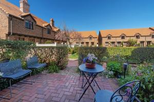 a patio with chairs and a table with flowers on it at Monaco Shores Apartment in Nelson