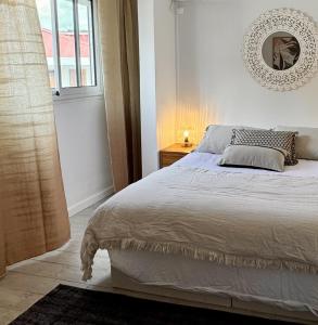 Un dormitorio con una cama y un espejo en la pared. en Pointe Noire, en Pointe-Noire