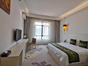 a hotel room with a bed and a flat screen tv at 慧兰酒店bodhi hotel in Ban Botèn