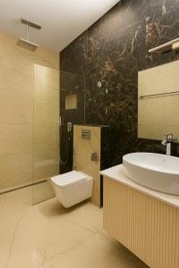 Un baño con lavabo, inodoro y ducha. en Coastal Echoes by Fortkochi Beach Inn, en Kochi