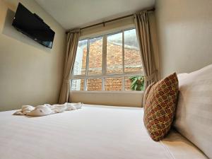 a bedroom with a bed with a large window at A Day inn Ranong Hostel in Ranong