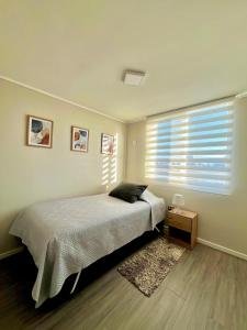 Depto a pasos de la playa 5-6 personas - La Serena في لا سيرينا: غرفة نوم بها سرير ونافذة بها ستائر +32 صورة