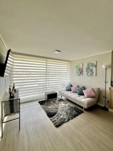 Depto a pasos de la playa 5-6 personas - La Serena في لا سيرينا: غرفة معيشة مع أريكة وسجادة