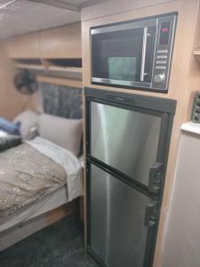 a microwave on top of a refrigerator in a room at Redwood Valley B and B Caravan Retreat in Redwoods Valley