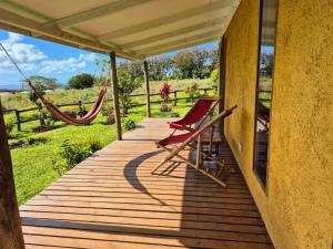 a porch with two chairs and a hammock on it at Villa Maori Tea Rapa Nui, Easter Island with ocean view in Hanga Roa