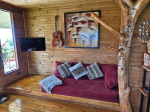 a living room with a red couch and a guitar at Villa Maori Tea Rapa Nui, Easter Island with ocean view in Hanga Roa