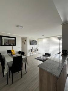 Depto a pasos de la playa 5-6 personas - La Serena في لا سيرينا: مطبخ وغرفة معيشة مع طاولة وكراسي