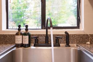 a kitchen sink with two bottles of wine at Cedar Terrace Townhome w Firepit in Lynnwood +21 photos