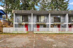 a house with red doors and a white fence at Cedar Terrace Townhome w Firepit in Lynnwood