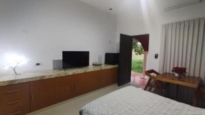 a bedroom with a bed and a flat screen tv at Casa Mango in Mérida
