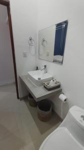 a white bathroom with a sink and a toilet at Casa Mangos in Mérida