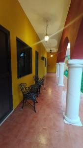 a hallway with chairs in a room with yellow walls at Casa Mango in Mérida +8 photos