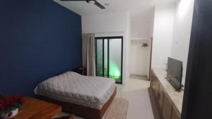 a bedroom with a bed and a television and a table at Casa Mango in Mérida