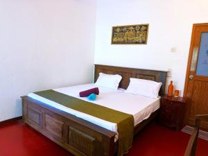 een slaapkamer met een bed met een koffer erop bij Surf Dine in Matara