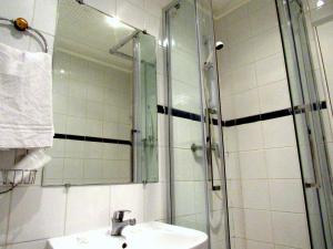 a bathroom with a shower and a sink and a mirror at Hôtel du Square d'Anvers in Paris