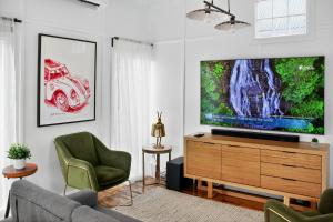 ein Wohnzimmer mit einem TV auf einer Holzkommode in der Unterkunft Cedar Cottage Daylesford in Daylesford