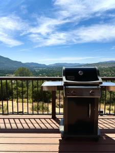een barbecue op een terras met uitzicht bij Relax Under the Stars, Best view in town , Yosemite House with Firepit, Hot Tub, Game Room & Pool table in Oakhurst