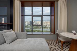 a living room with a couch and a large window at WYNDHAM TAIYUAN in Taiyuan