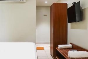 une chambre avec un lit et une télévision sur un mur dans l'établissement Collection O Kk Trends, à Vijayawada 42 autres photos