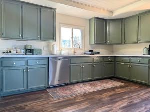 een keuken met groene kasten en een spoelbak bij Relax Under the Stars, Best view in town , Yosemite House with Firepit, Hot Tub, Game Room & Pool table in Oakhurst +27 foto's