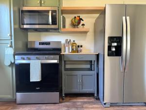 een keuken met een fornuis en een koelkast bij Relax Under the Stars, Best view in town , Yosemite House with Firepit, Hot Tub, Game Room & Pool table in Oakhurst